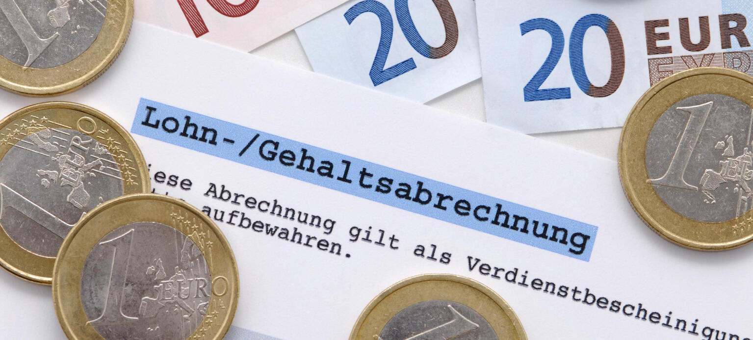 Foto mit Euro-Münzen und -Scheinen, Gehaltsabrechnung